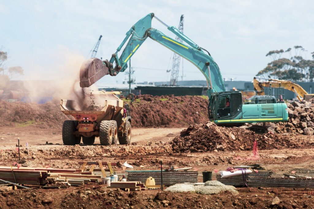 An excavator loading a dumper on a groundworks site